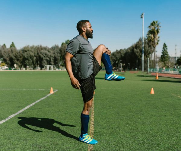 A man stretching outdoors at sunrise, feeling energized and focused.
